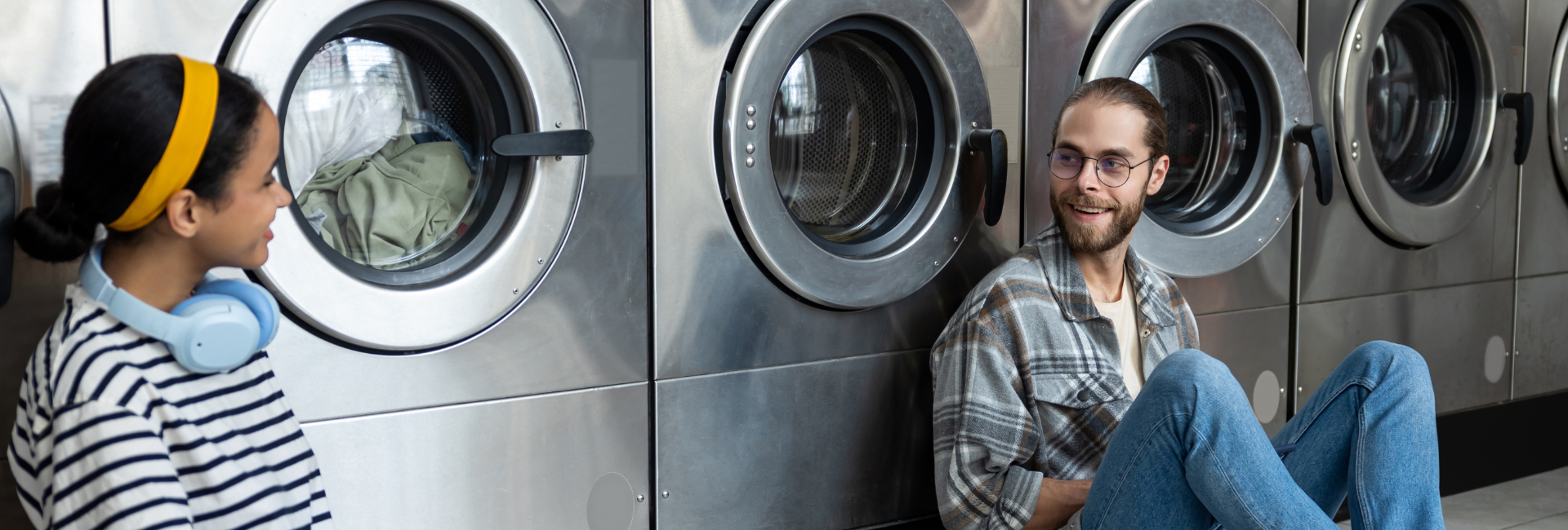 Two People Chatting At The Laundromat 1920X650